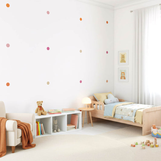 Le soleil illumine les stickers pois orange et beige sur le mur, un détail de décoration murale qui apporte une ambiance chaleureuse à la chambre d'enfant au Maroc.