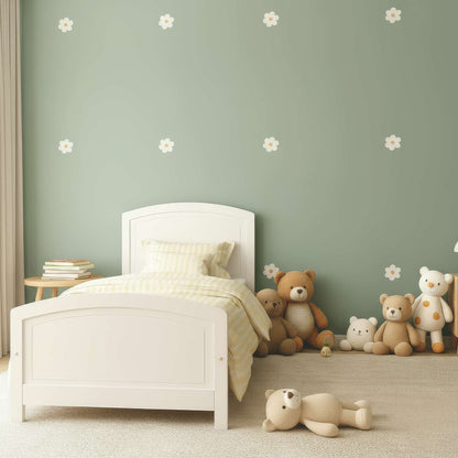 Des stickers fleurs marguerites beiges sur un mur vert, un élément de décoration murale qui apporte une touche de nature et de charme à une chambre d'enfant au Maroc.