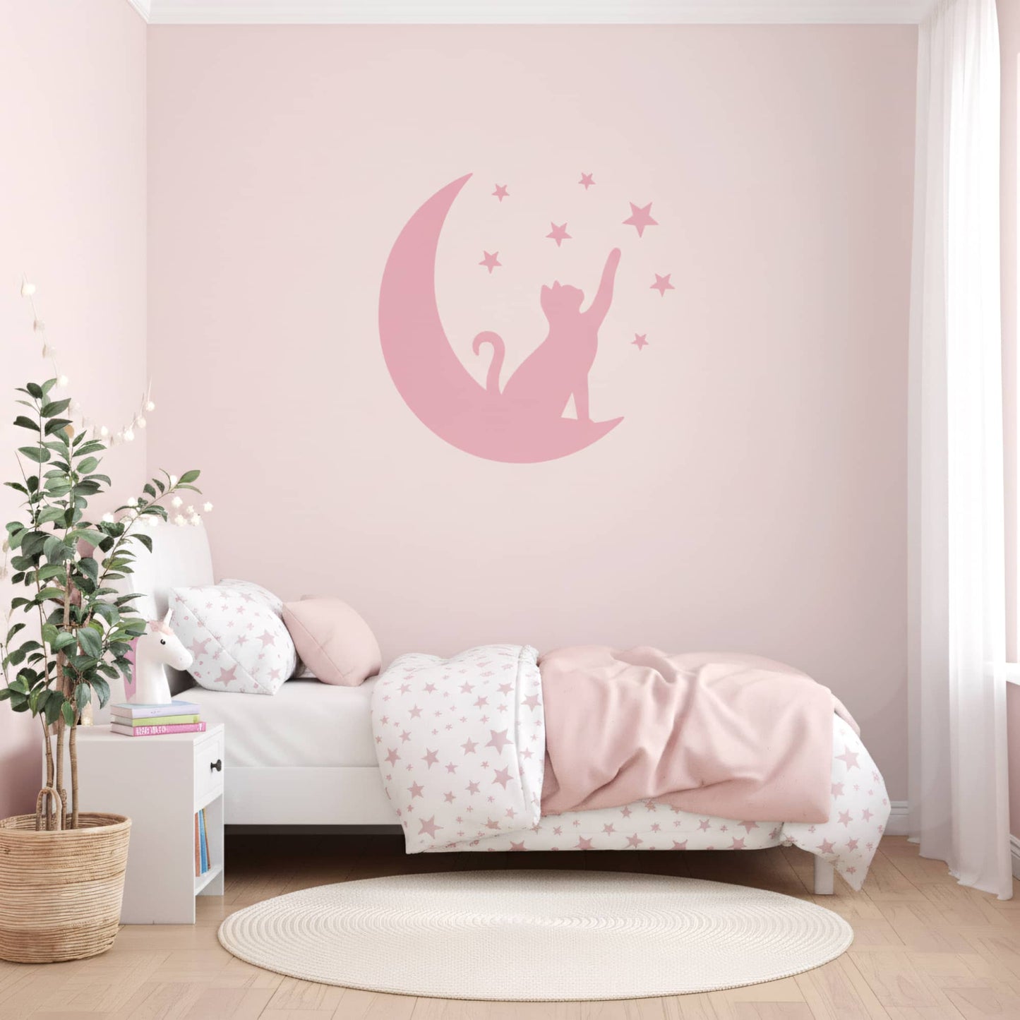 Une chambre fille avec des murs peints en rose et un grand sticker mural de Chat Lunaire rose, créant une ambiance harmonieuse pour la décoration chambre enfant au Maroc.