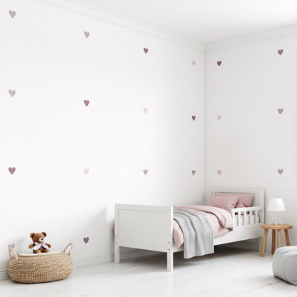Une chambre d'enfant bien aménagée avec des stickers cœurs teintes violet sur le mur, créant une ambiance ludique et harmonieuse au Maroc.