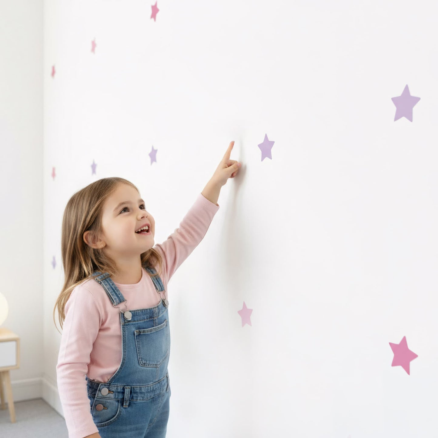 Une jeune fille joyeuse pointant du doig les stickers étoiles rose bonbon 