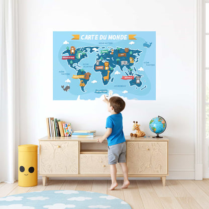Jeune enfant devant un grand sticker mural carte du monde. Décoration murale parfaite pour une chambre enfant au Maroc. Stickers animaux du monde.