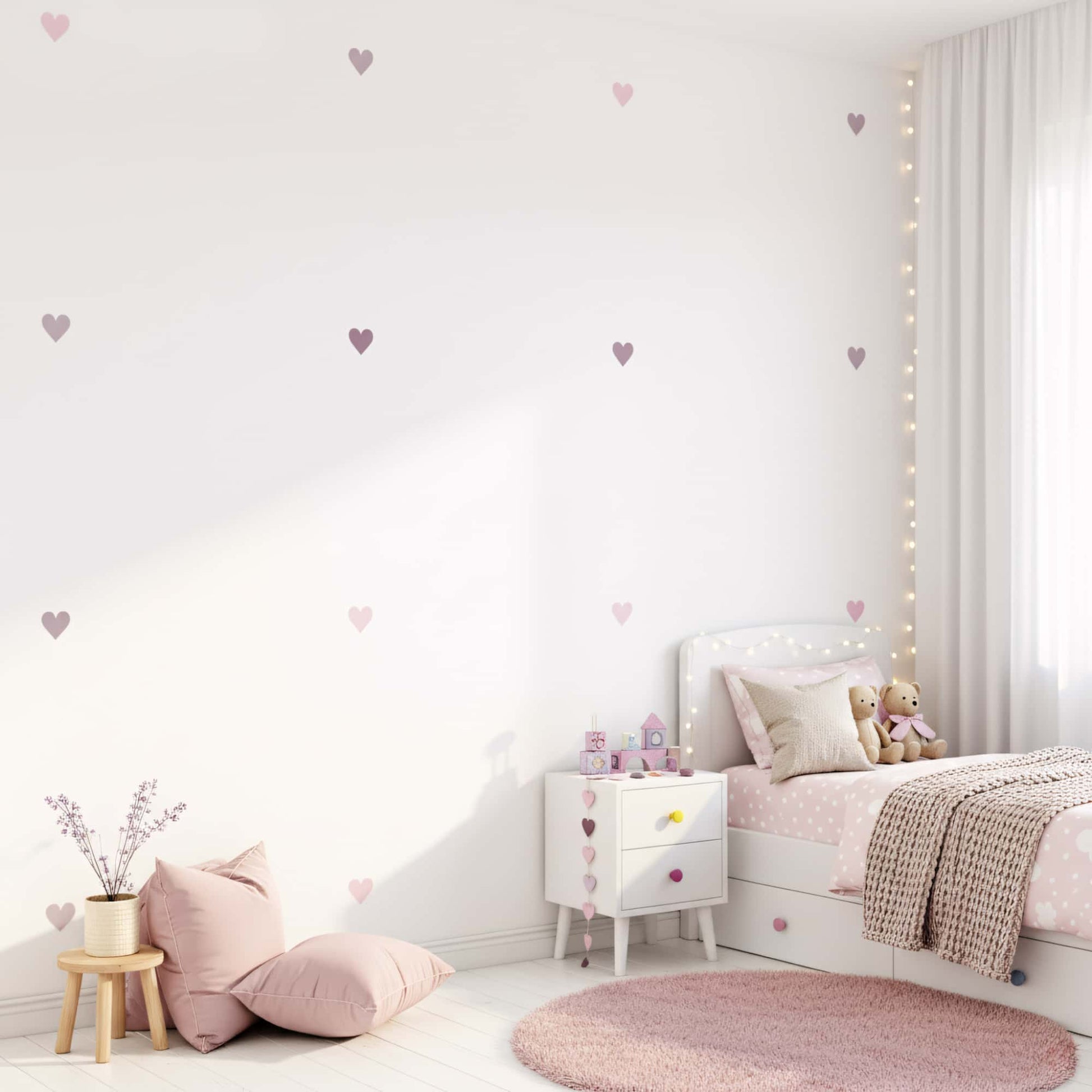 Lit et table de chevet dans une chambre enfant au Maroc, les murs sont ornés de stickers coeurs en Teintes Violet, créant une atmosphère douce et accueillante.