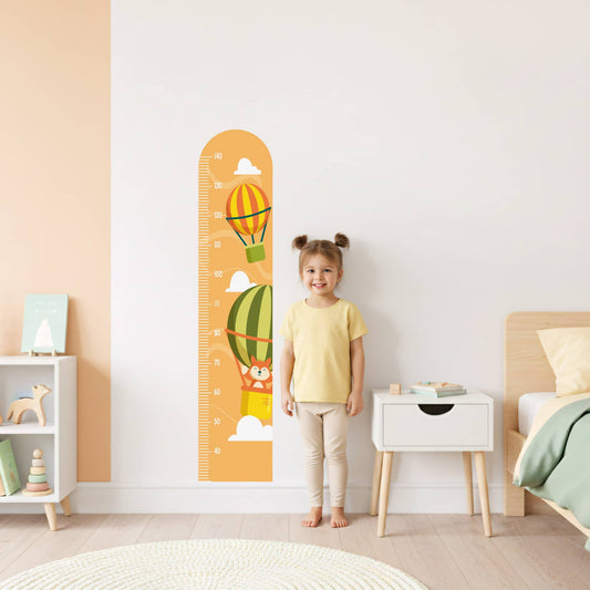 Enfant devant la règle de croissance Montgolfières, stickers muraux de décoration pour chambre d'enfant au Maroc.