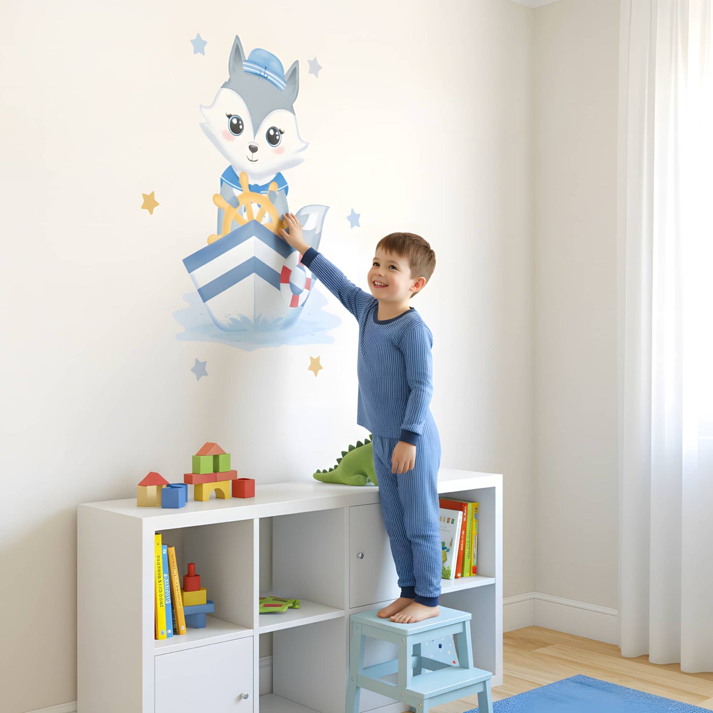 Enfant souriant posant un grand sticker animaux du Renard Marin sur le mur, un excellent exemple de décoration murale pour une chambre enfant au Maroc.