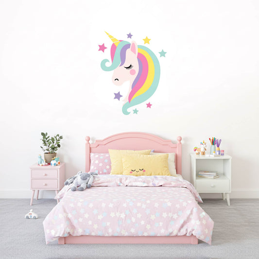 Grand sticker mural licorne pastel au-dessus d'un lit enfant rose. Une idée de décoration murale magique pour chambre de fille. Stickers Pixelou au Maroc.