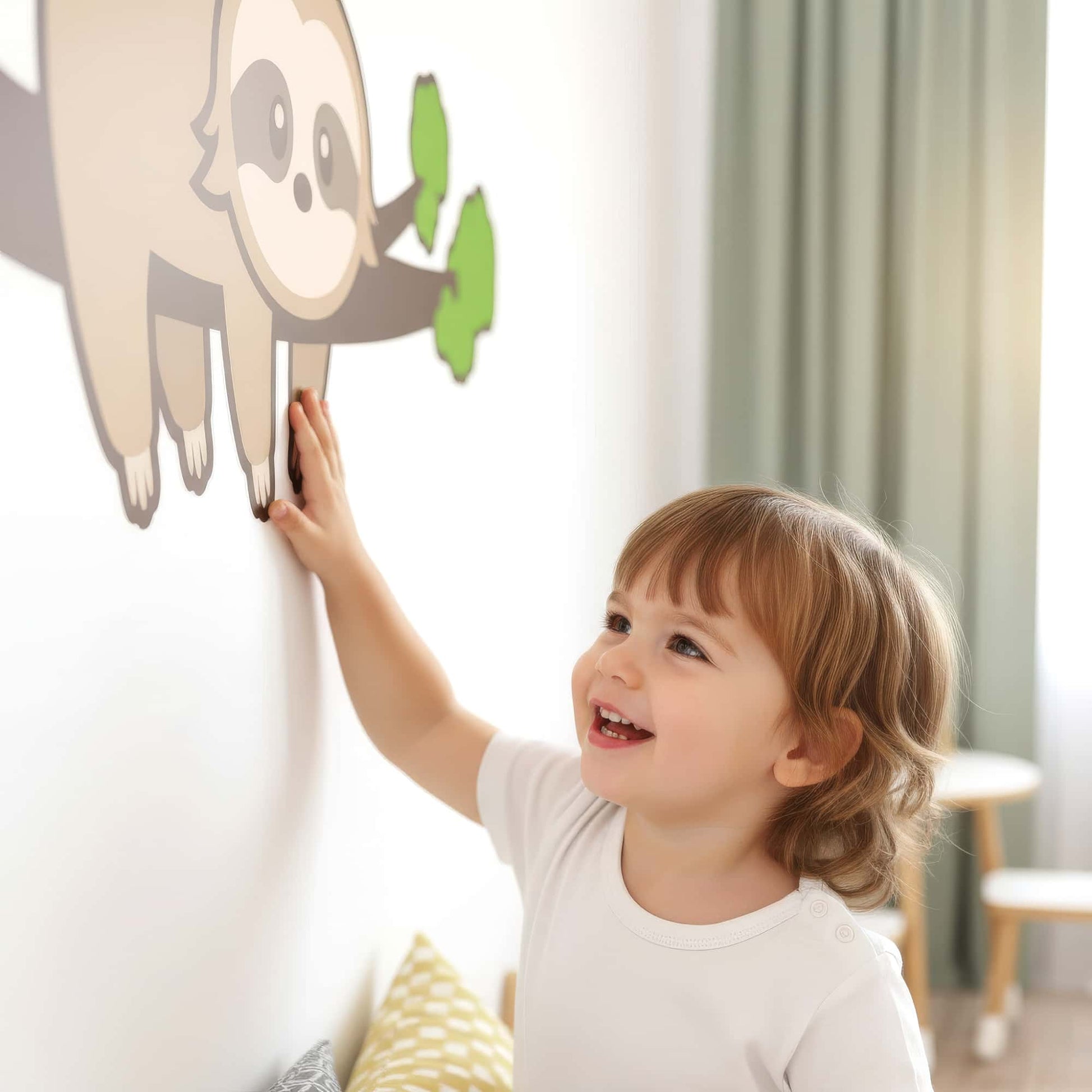 Un bébé s'amuse à toucher le sticker animal paresseux, montrant à quel point ce grand sticker est doux et captivant pour la décoration de la chambre de bébé au Maroc.
