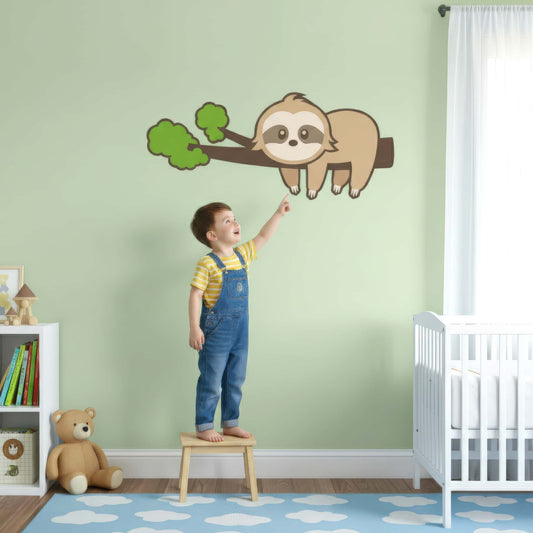 Un enfant pointe du doigt son nouveau sticker animal préféré. Ce grand sticker paresseux est un élément de décoration murale amusant et stimulant pour une chambre d'enfant.