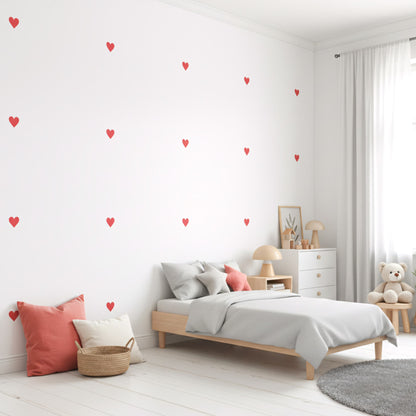 Stickers cœurs rouges amour sur un mur blanc, créant une décoration murale vive et affectueuse pour une chambre d'enfant au Maroc.