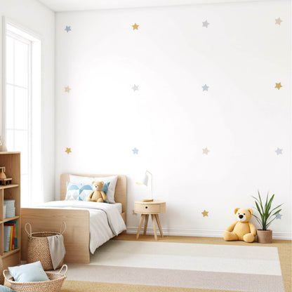 Stickers étoiles bleu doré sur un mur blanc, créant une décoration murale élégante et cosmique pour une chambre de garçon au Maroc.