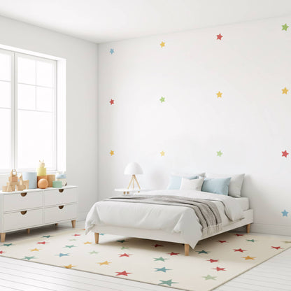 Un enfant joue tranquillement devant les stickers étoiles multicolores, un fond de décoration murale parfait pour un espace de jeu dans la chambre d'enfant.