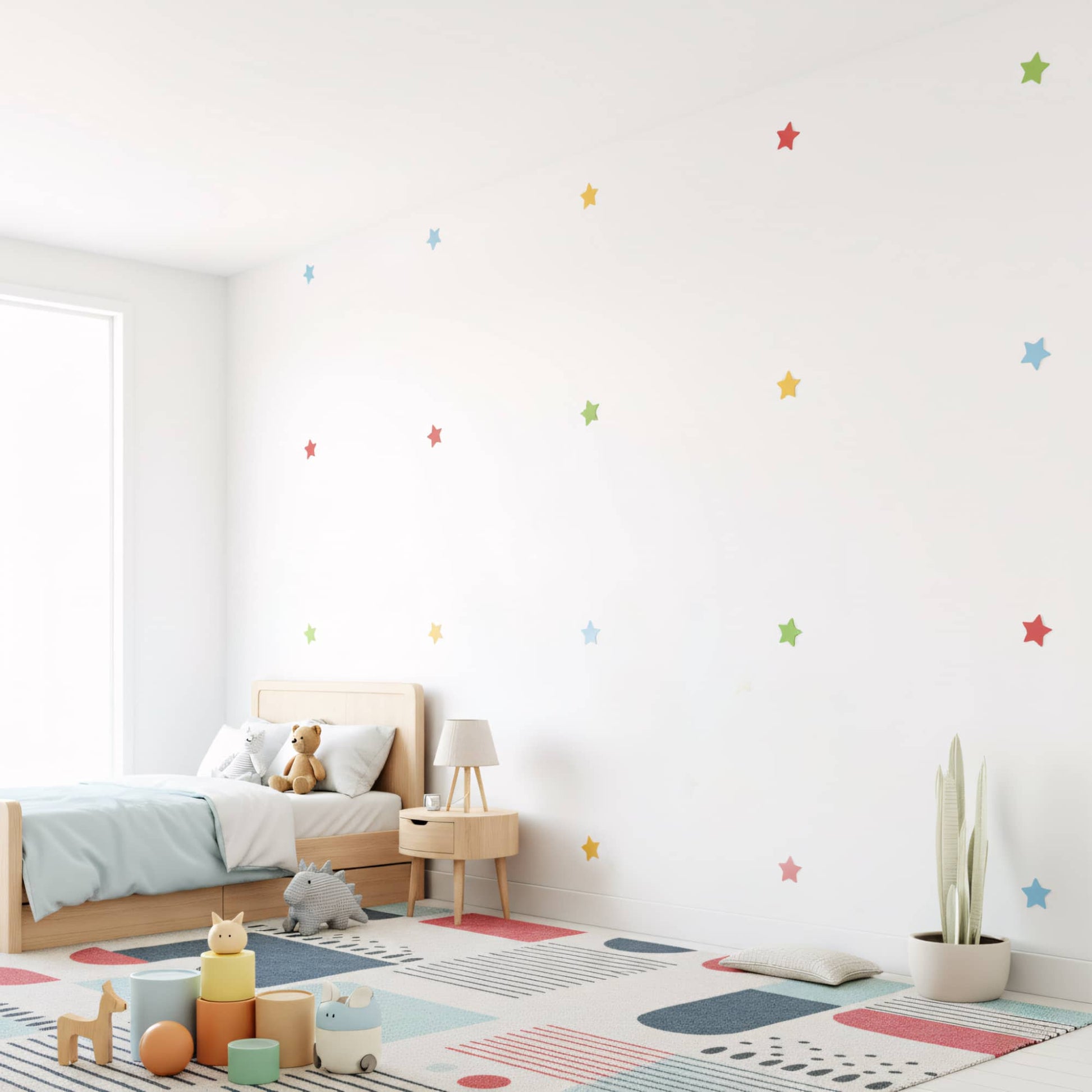 Stickers étoiles multicolores dispersés sur un mur blanc, créant une ambiance de ciel étoilé et joyeuse pour la décoration murale de chambre de bébé au Maroc.