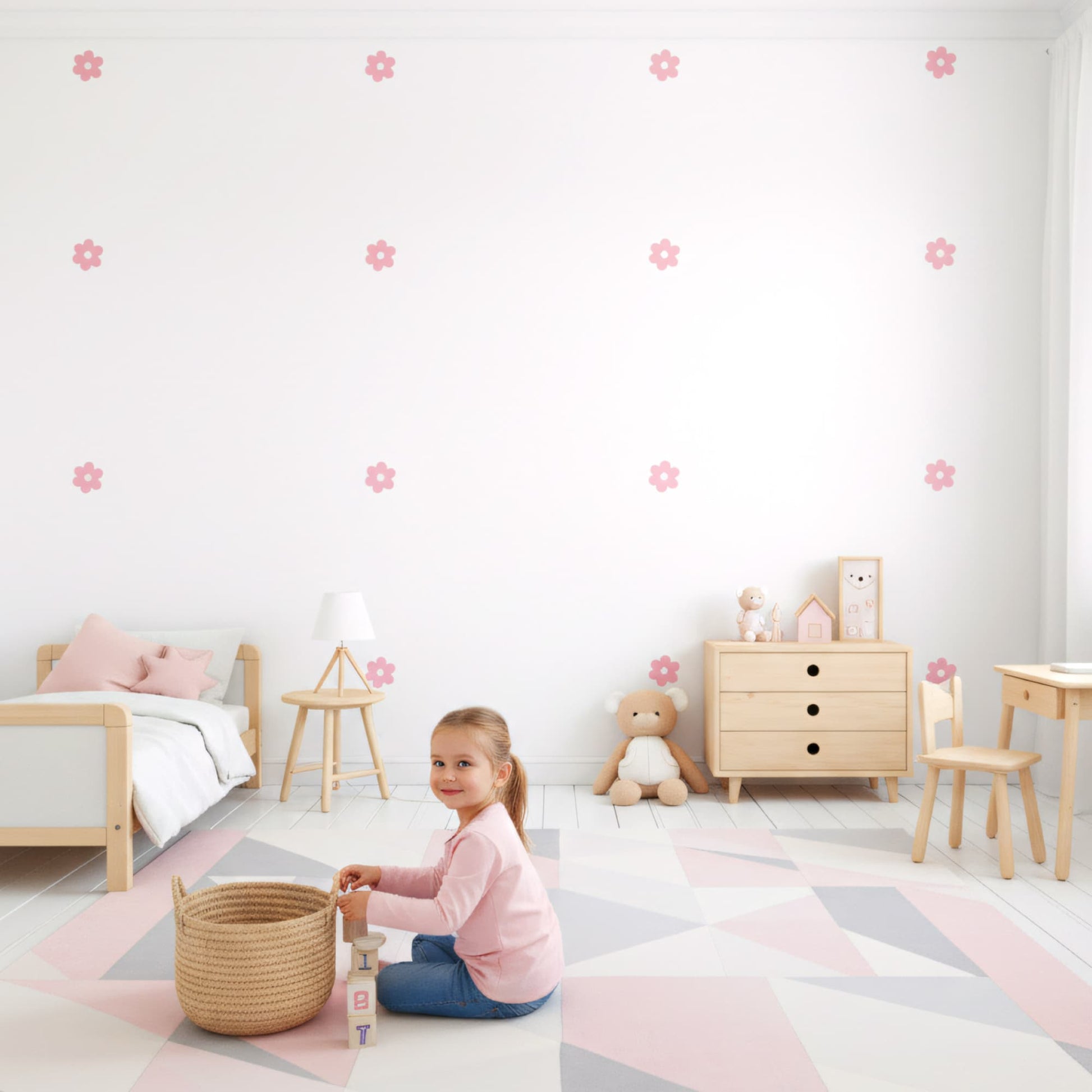 Lit de bébé avec un mobile coloré, entouré de stickers fleurs marguerites roses. Une décoration murale qui apporte douceur et nature à la chambre de bébé au Maroc.