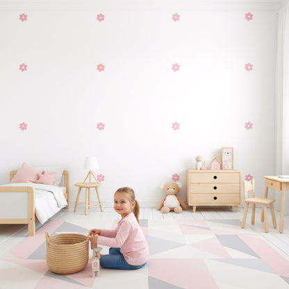 Lit de bébé avec un mobile coloré, entouré de stickers fleurs marguerites roses. Une décoration murale qui apporte douceur et nature à la chambre de bébé au Maroc.