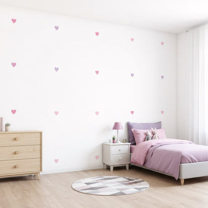 Un lit d'enfant blanc est mis en valeur par des stickers muraux cœurs rose bonbon, apportant une touche de couleur et d'amour à cette chambre de bébé au Maroc.