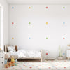 Stickers muraux étoiles multicolores sur un mur blanc, un élément de décoration murale qui stimule l'imagination dans une chambre d'enfant au Maroc.
