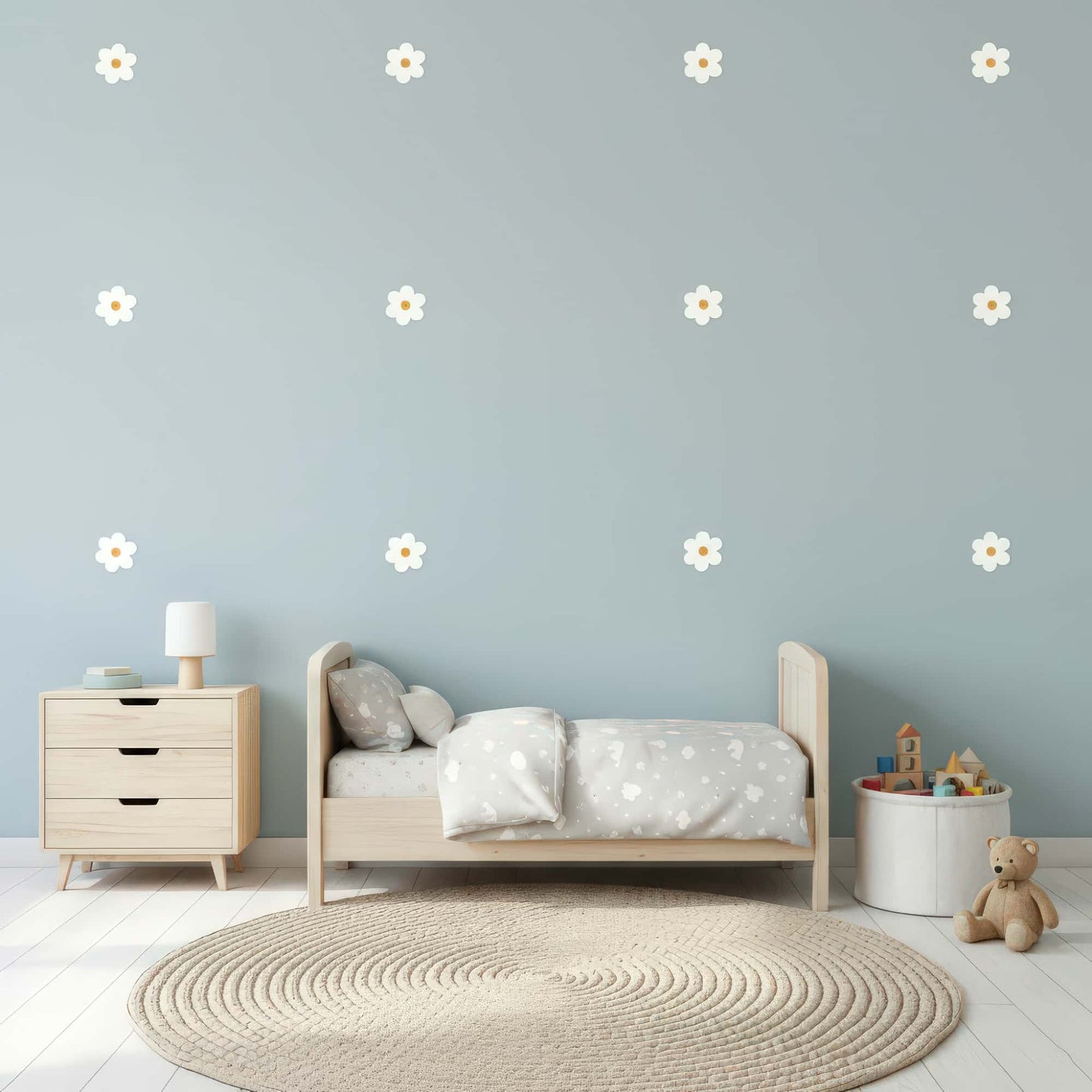 Des stickers fleurs marguerites blanches sur un mur bleu clair, une décoration murale qui apporte douceur et légèreté à une chambre de bébé au Maroc.