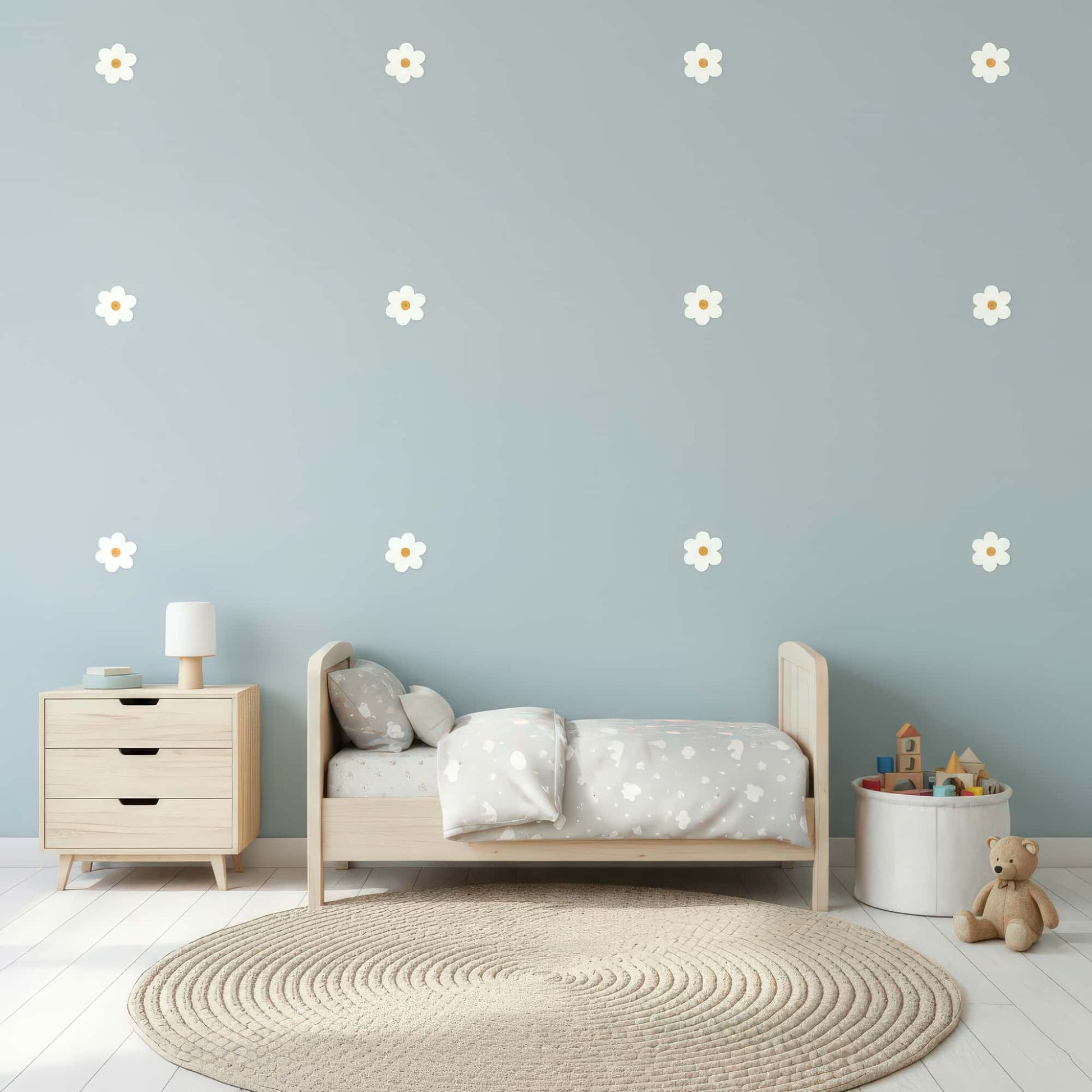 Des stickers fleurs marguerites blanches sur un mur bleu clair, une décoration murale qui apporte douceur et légèreté à une chambre de bébé au Maroc.