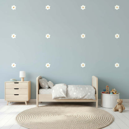 Des stickers fleurs marguerites blanches sur un mur bleu clair, une décoration murale qui apporte douceur et légèreté à une chambre de bébé au Maroc.