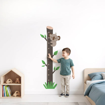 Enfant souriant devant la toise stickers muraux Koala Arbre, idéale pour la décoration de chambre d'enfant au Maroc.