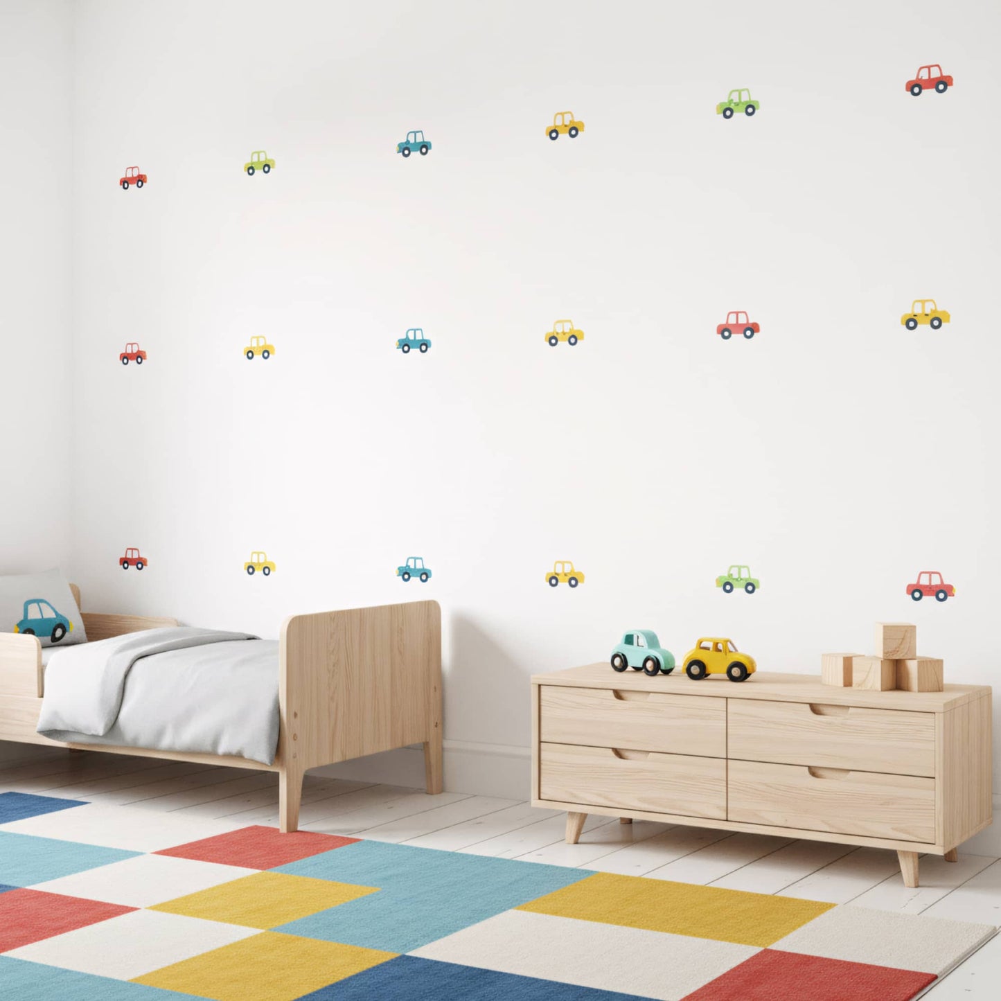 Stickers de voitures colorées disposés sur un mur blanc dans une chambre enfant. Parfait pour la décoration murale au Maroc. Multicolore