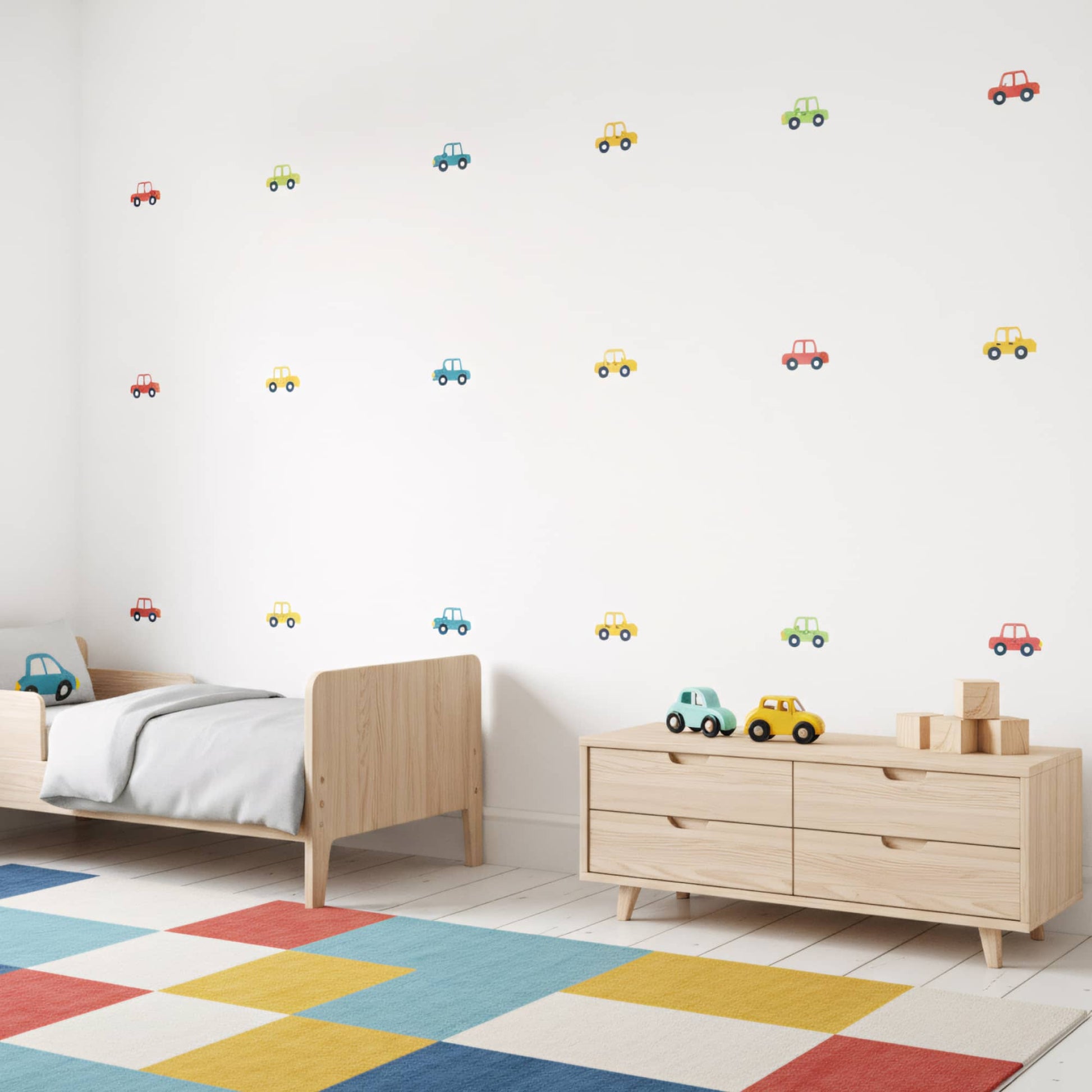 Stickers de voitures colorées disposés sur un mur blanc dans une chambre enfant. Parfait pour la décoration murale au Maroc. Multicolore